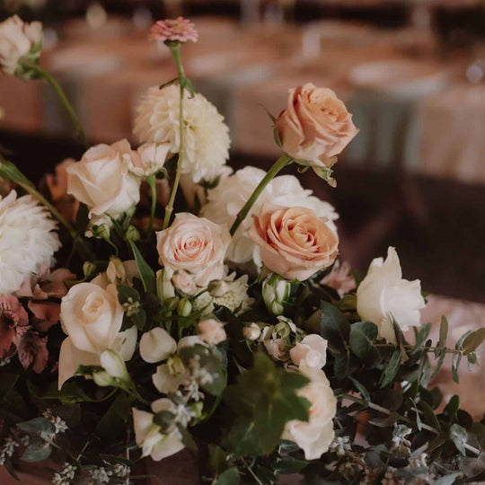 Floral arrangement with roses and greenery on a blurred background