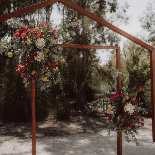 Wooden archway decorated with flowers in a natural setting